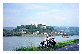 Bikers pose along the Danube Bicycle Path with castle in background